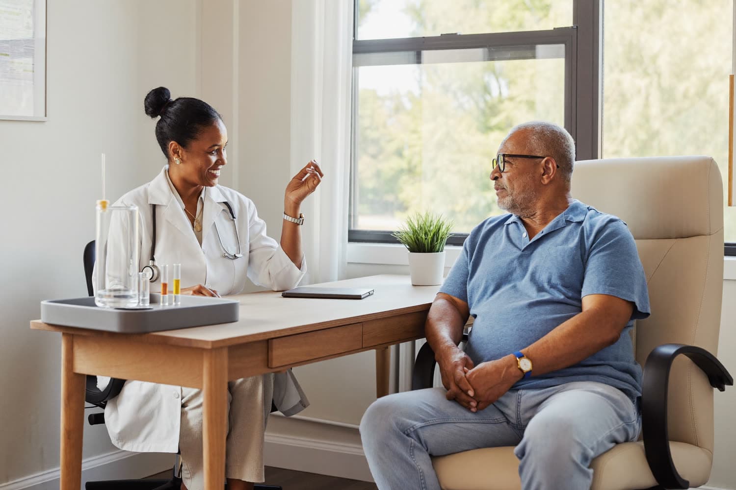 A doctor discussing cancer screening with a patient in a bright consulting room